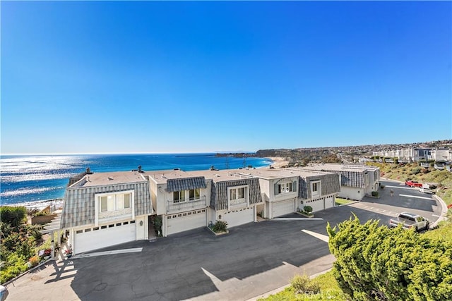 view of front facade featuring a view of the beach, a garage, and a water view