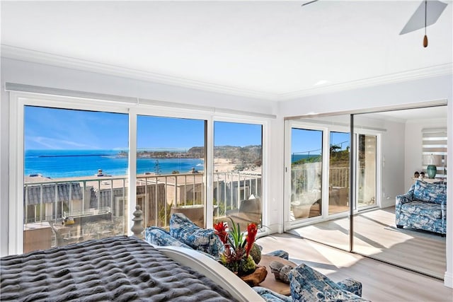 bedroom with a water view, ornamental molding, access to exterior, and hardwood / wood-style floors