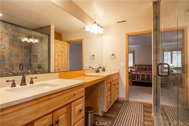 bathroom with a shower with shower door, vanity, and hardwood / wood-style floors