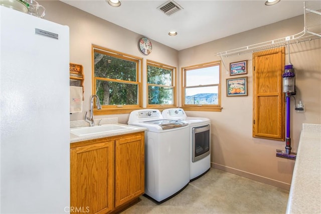 washroom featuring recessed lighting, visible vents, cabinet space, washing machine and dryer, and a sink