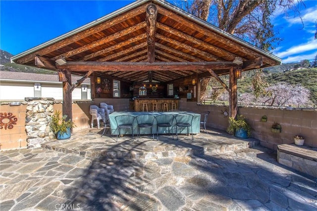 view of patio / terrace featuring outdoor dry bar and fence