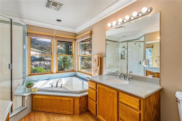 bathroom featuring visible vents, a stall shower, vanity, wood finished floors, and a jetted tub