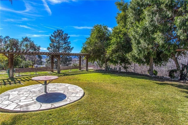 view of property's community with a lawn, a patio area, and fence