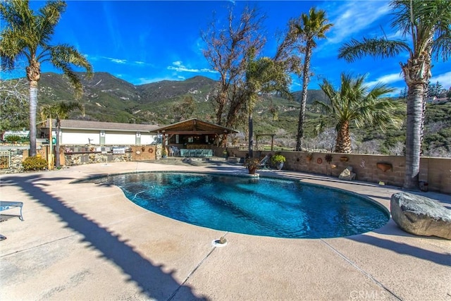 view of pool featuring a patio, a mountain view, fence, a gazebo, and a fenced in pool