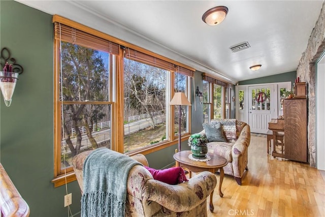 sunroom / solarium featuring lofted ceiling and visible vents