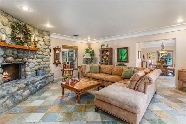 living area with crown molding, recessed lighting, visible vents, stone finish flooring, and a stone fireplace