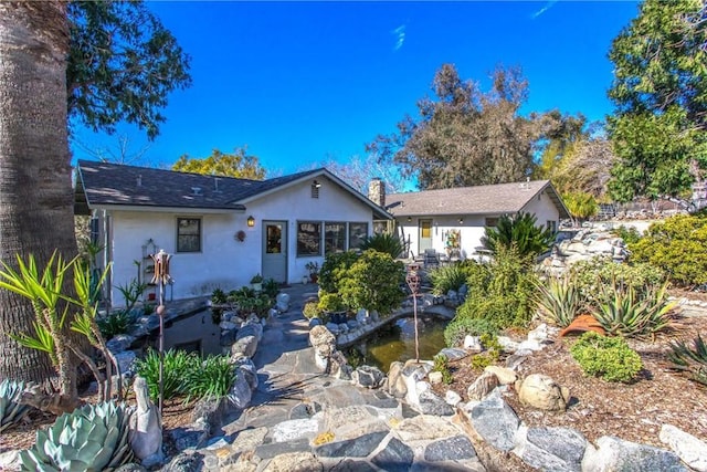 view of front of home with a chimney and stucco siding