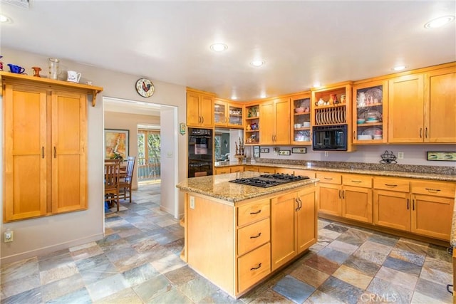 kitchen with light stone countertops, recessed lighting, a center island, black appliances, and glass insert cabinets