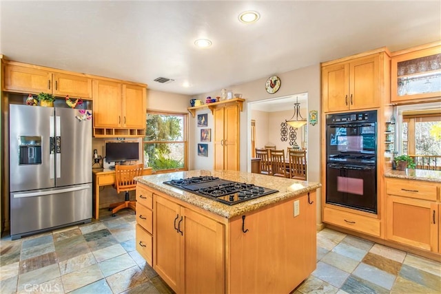 kitchen featuring dobule oven black, visible vents, light stone counters, gas cooktop, and stainless steel refrigerator with ice dispenser