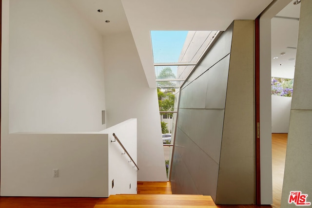 stairway featuring expansive windows and wood-type flooring