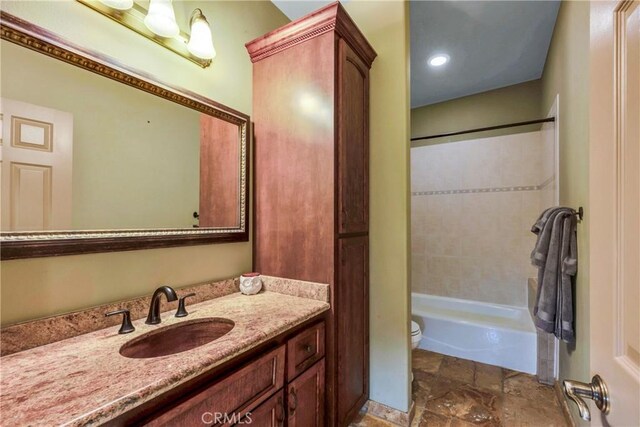 full bathroom featuring vanity, toilet, and tiled shower / bath