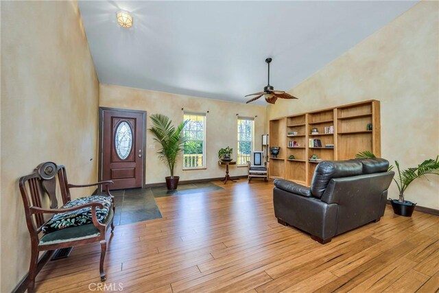 living room featuring ceiling fan, high vaulted ceiling, and hardwood / wood-style flooring