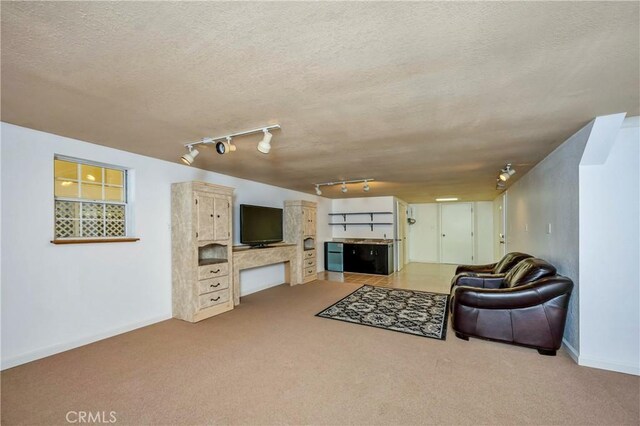 living room with light carpet, a textured ceiling, and track lighting