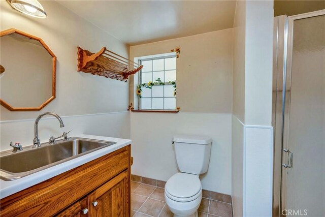 bathroom with tile patterned floors, vanity, walk in shower, and toilet