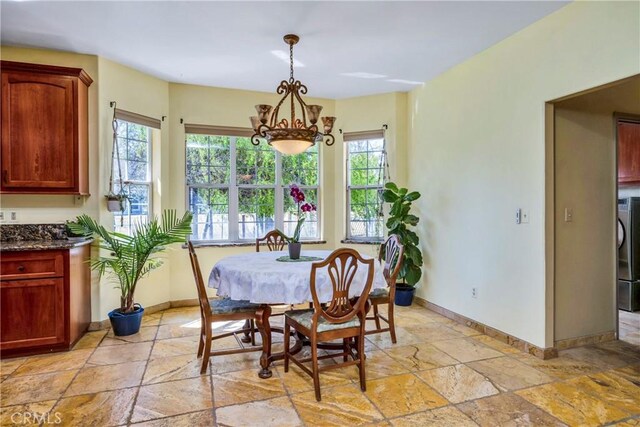 dining room with washer / clothes dryer and a notable chandelier