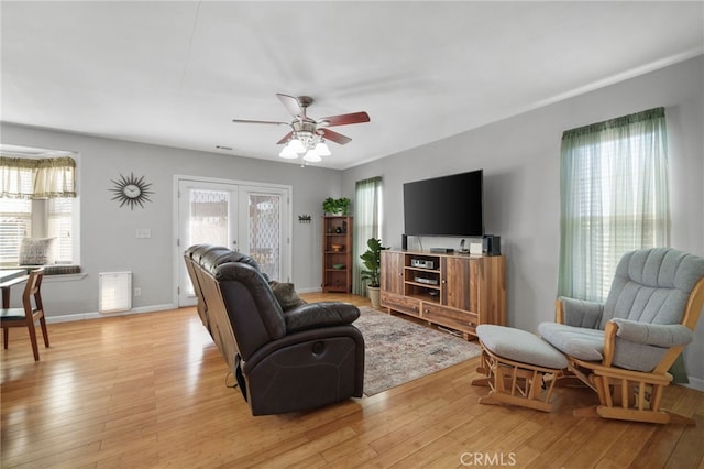 living room with ceiling fan, french doors, a healthy amount of sunlight, and light hardwood / wood-style floors