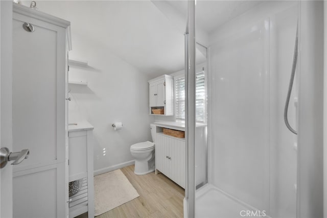 bathroom with a shower, wood-type flooring, vanity, and toilet