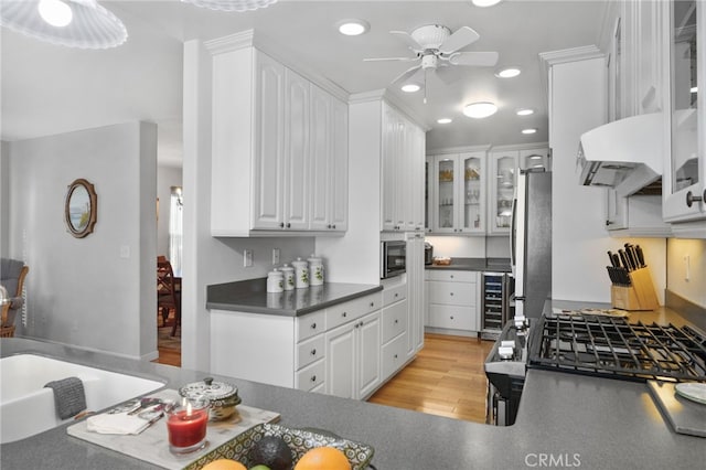 kitchen featuring white cabinetry, stainless steel appliances, beverage cooler, custom range hood, and light wood-type flooring