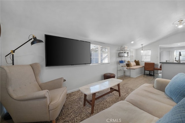 living room with light wood-type flooring and vaulted ceiling