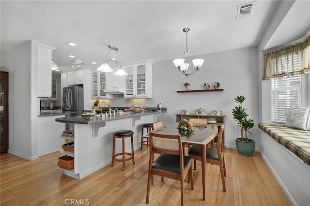 dining area with an inviting chandelier and light hardwood / wood-style flooring