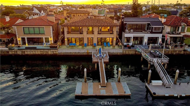 back house at dusk with a water view