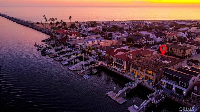 aerial view at dusk featuring a water view