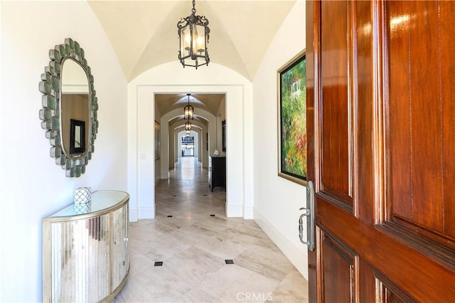 foyer featuring a notable chandelier and lofted ceiling