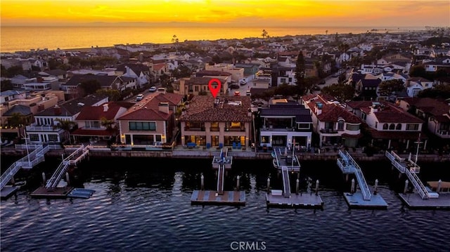 aerial view at dusk featuring a water view