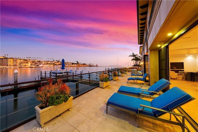 view of patio / terrace with a water view and a balcony