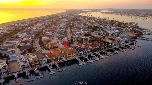 aerial view at dusk featuring a water view