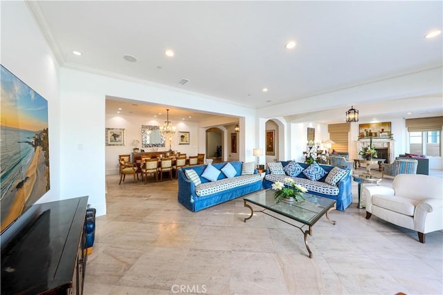 living room with crown molding and a chandelier