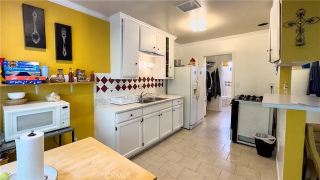 kitchen featuring white cabinets, light tile floors, backsplash, white appliances, and ornamental molding