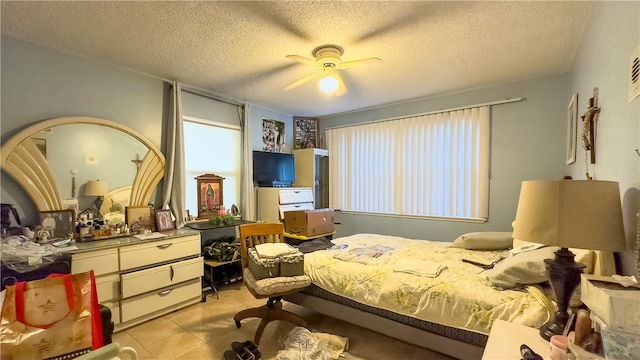 tiled bedroom featuring ceiling fan and a textured ceiling