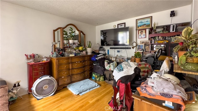 miscellaneous room with a textured ceiling and light hardwood / wood-style floors