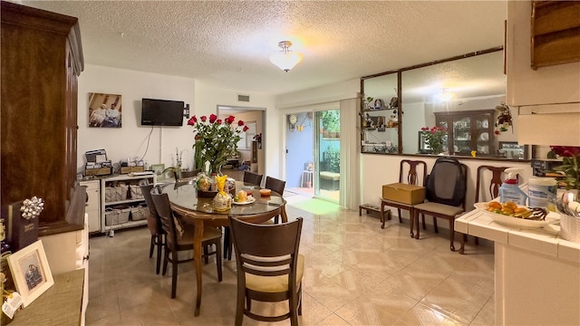 dining area with light tile floors and a textured ceiling