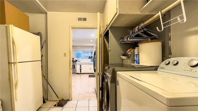 laundry room featuring washing machine and clothes dryer and light tile floors