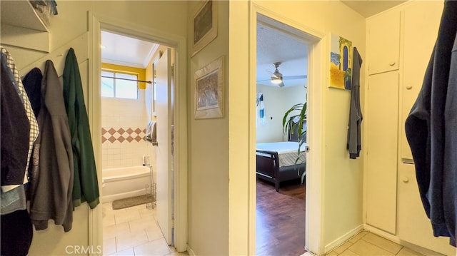 corridor featuring crown molding and light tile floors