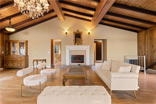 living room featuring beam ceiling, an inviting chandelier, high vaulted ceiling, wooden ceiling, and light hardwood / wood-style floors