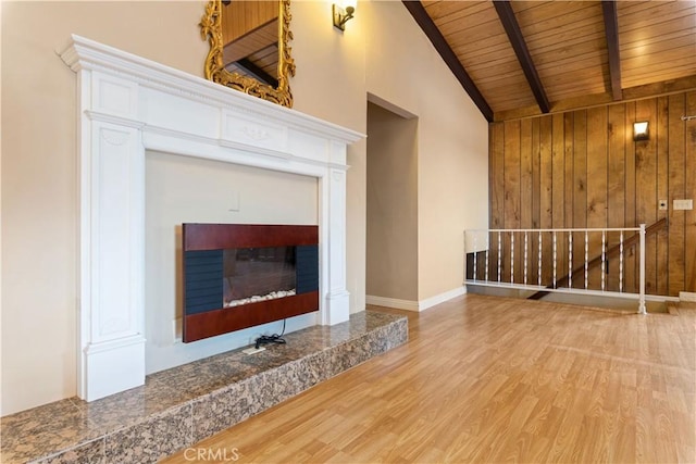 unfurnished living room featuring wooden walls, light hardwood / wood-style floors, wood ceiling, and high vaulted ceiling