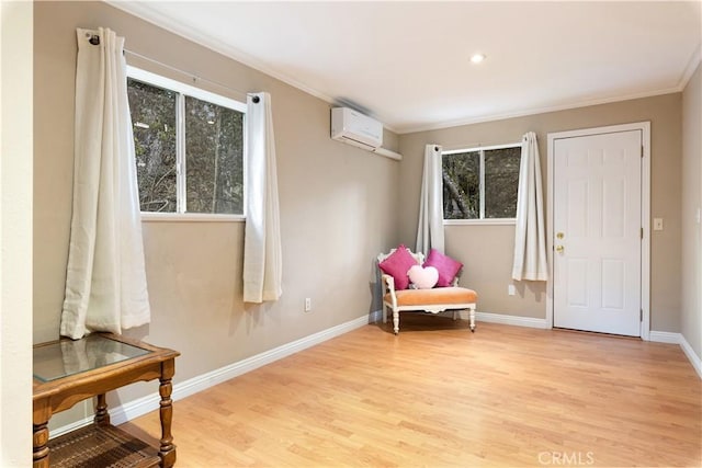 living area featuring light wood-type flooring, a wall unit AC, and crown molding