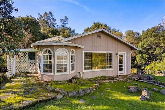 rear view of property featuring a lawn