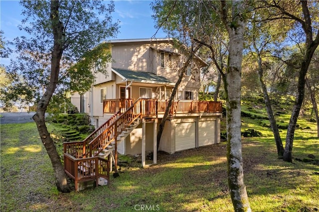 rear view of house with a yard and a deck