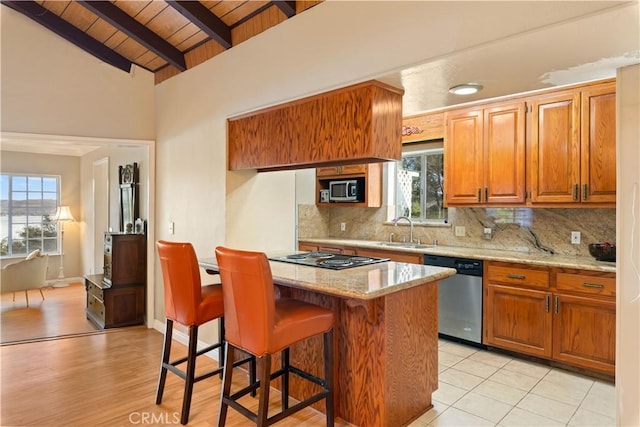 kitchen with a kitchen bar, appliances with stainless steel finishes, tasteful backsplash, and wood ceiling