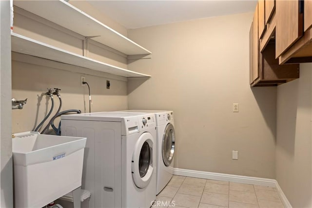 laundry room with washer and dryer, cabinets, light tile patterned floors, and sink