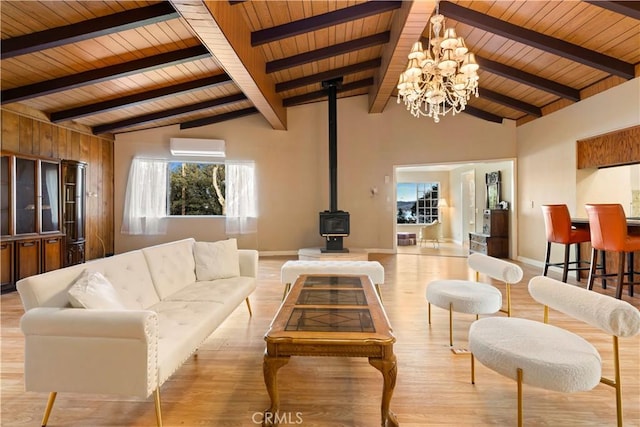 living room featuring a wood stove, beam ceiling, light hardwood / wood-style floors, wood ceiling, and a chandelier