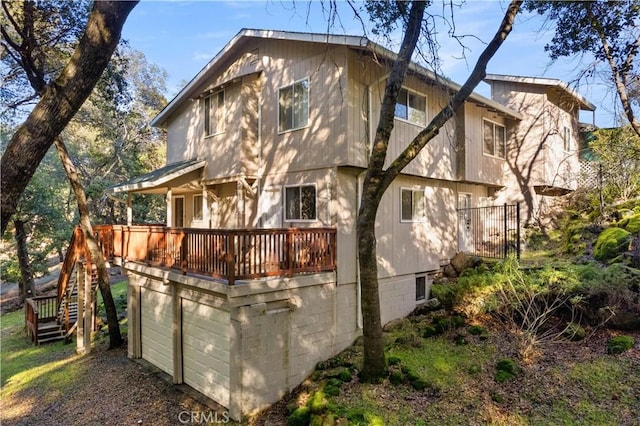 back of house with a deck and a garage