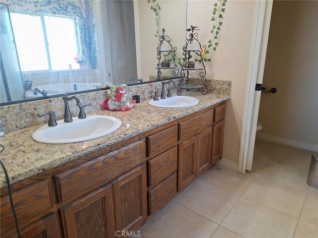 bathroom featuring toilet, vanity, tile patterned floors, and a bath