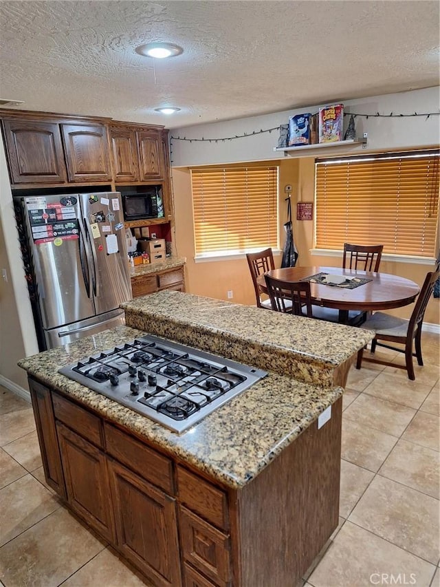 kitchen featuring light tile patterned flooring, stainless steel appliances, and a textured ceiling