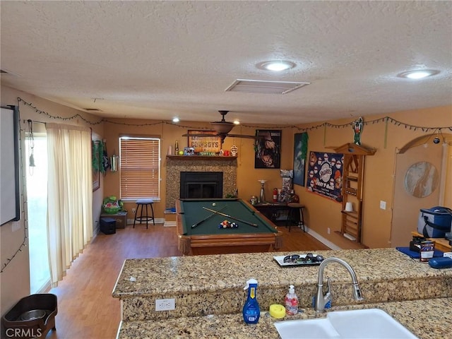 playroom featuring wood-type flooring, sink, a textured ceiling, and pool table