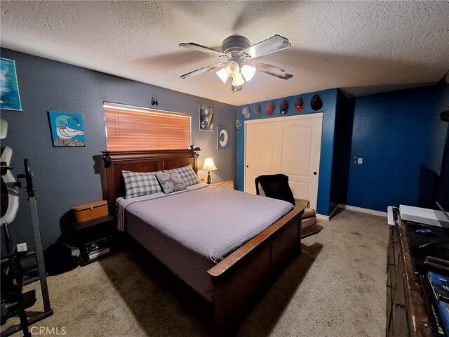 bedroom featuring a textured ceiling, ceiling fan, and dark colored carpet